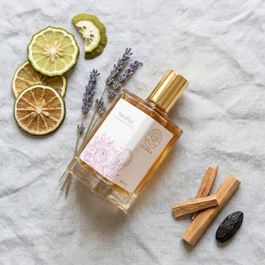 Svara perfume bottle next to raw botanical ingredients like sandalwood and rose petals